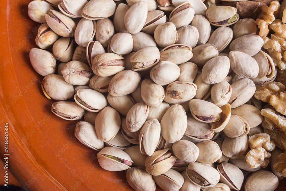 A portion of pistachios in a clay pot. Healthy snacks and food. A portion of pistachios in a clay pot. Healthy snacks and food.