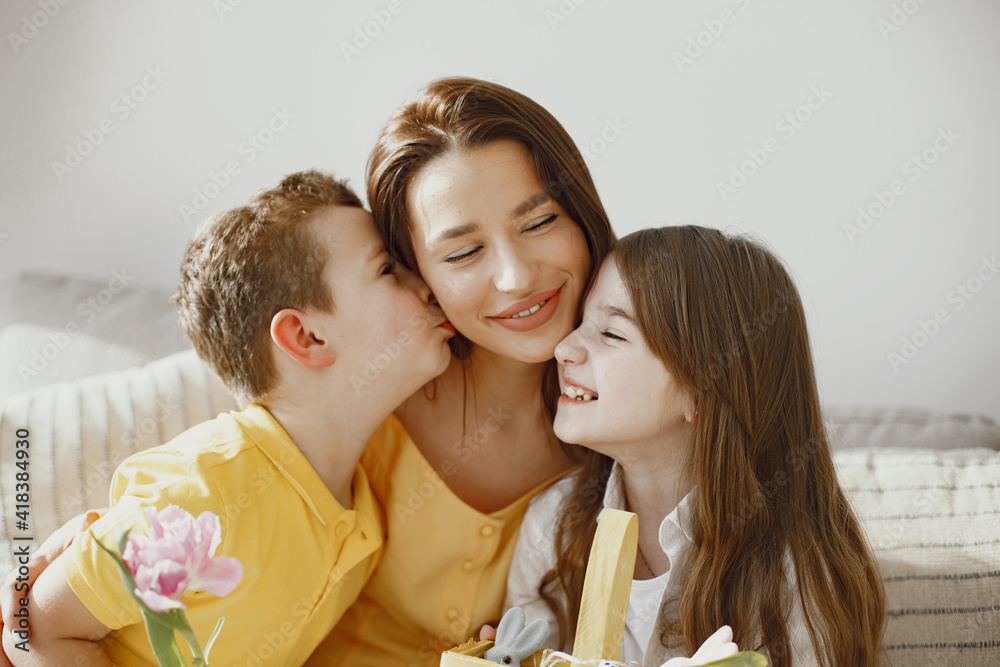 Mother with daughter and son at home. Make up a holiday basket. In festive clothes Mother with daughter and son at home. Make up a holiday basket. In festive clothes