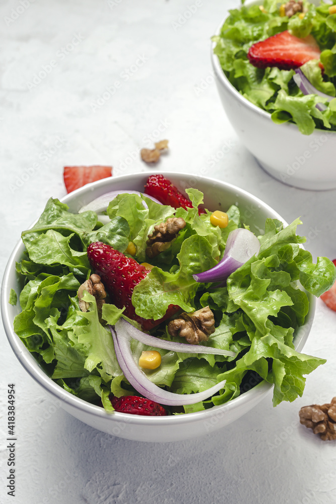 Salad with lettuce, strawberries, red onion, corn; olive oil and walnuts Salad with lettuce, strawberries, red onion, corn; olive oil and walnuts