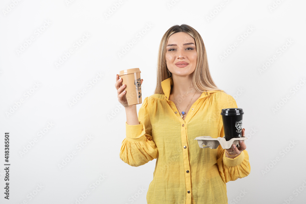 Portrait of young woman posing with cups of coffee on white background Portrait of young woman posing with cups of coffee on white background