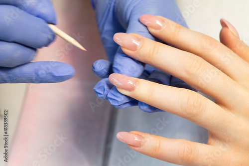 Manicure procedure. The process of strengthening natural nails with gel polish by a manicure master.