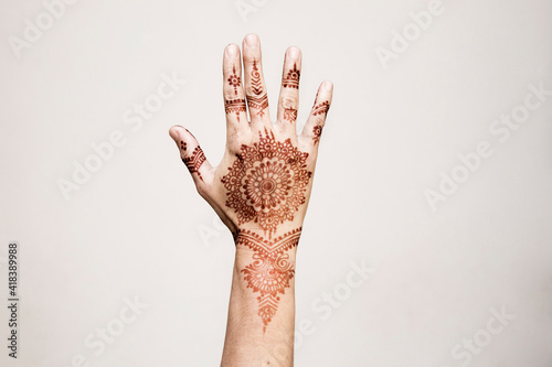 Hand with henna tattoo making gesture photo