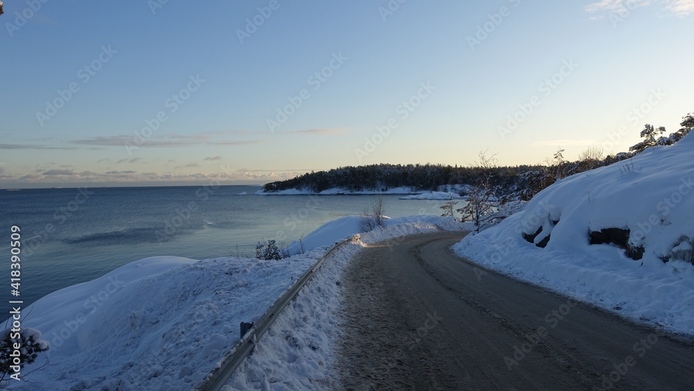 The sun has set on a road near the sea