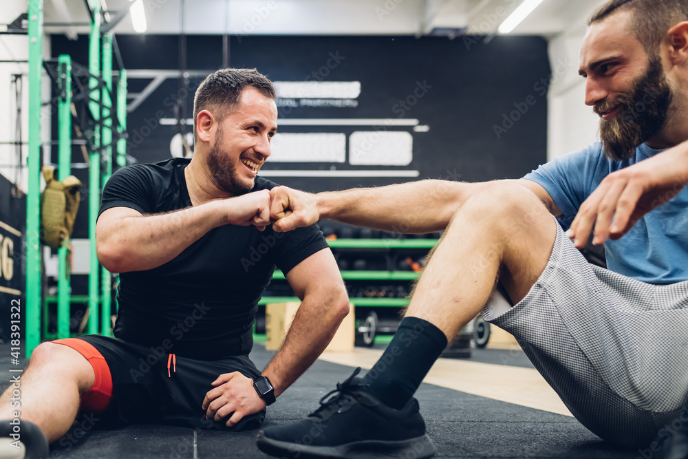 Personal trainer and man with disability enjoying conversation in gym Personal trainer and man with disability enjoying conversation in gym