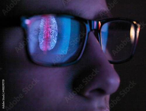 Cyber Security, reflection in spectacles  of access information being scanned on computer screen, close up of face