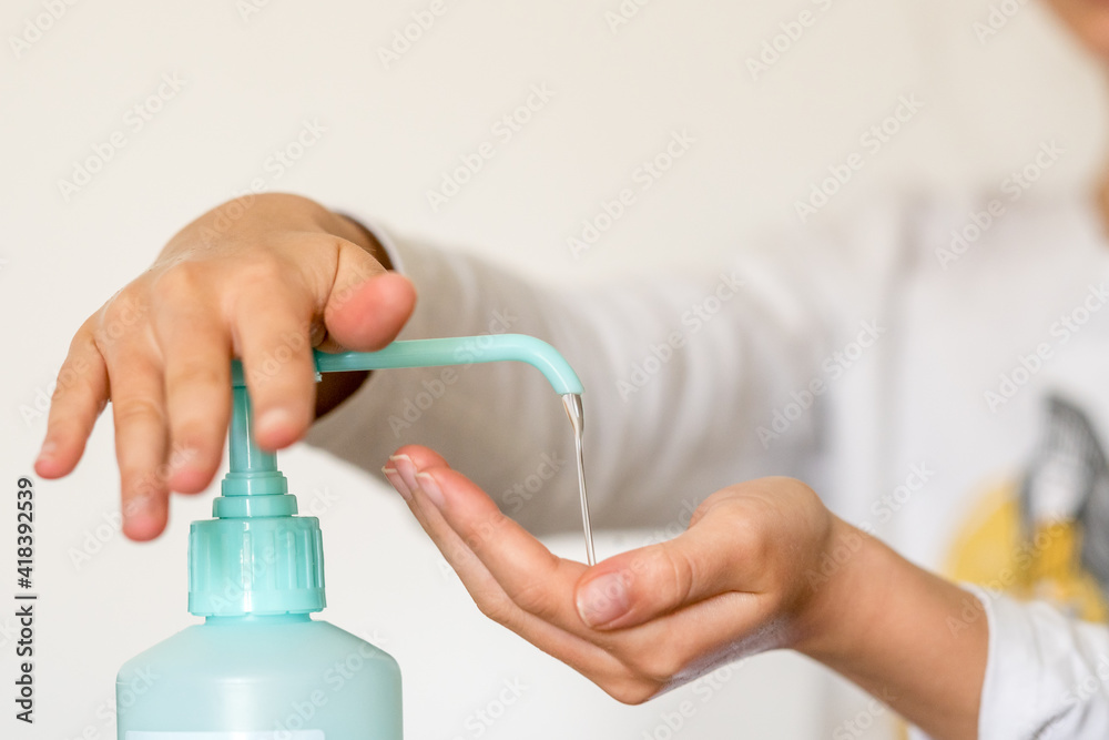 Fototapeta premium Enfant se lavant les mains acec du gel hydroalcoolique