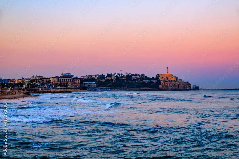 Seascape with distant view of old port skyline and Church of St Peter at dawn, Jaffa, Tel Aviv, Israel Seascape with distant view of old port skyline and Church of St Peter at dawn, Jaffa, Tel Aviv, Israel