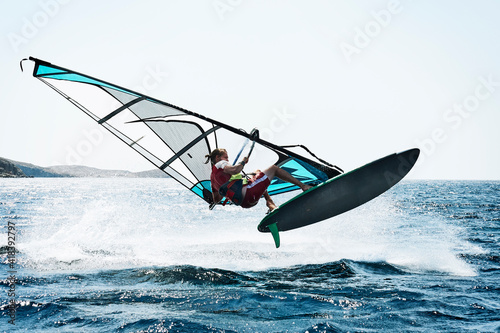 Young man windsurfing above ocean waves, Limnos, Khios, Greece photo