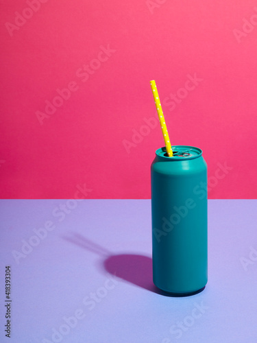 Still life of turquoise drink can with yellow straw and pink background
