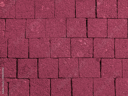 Brickwork of big bright textured crimson pink bricks, geometric square stones. Floor in a street, tiles underfoot. Background