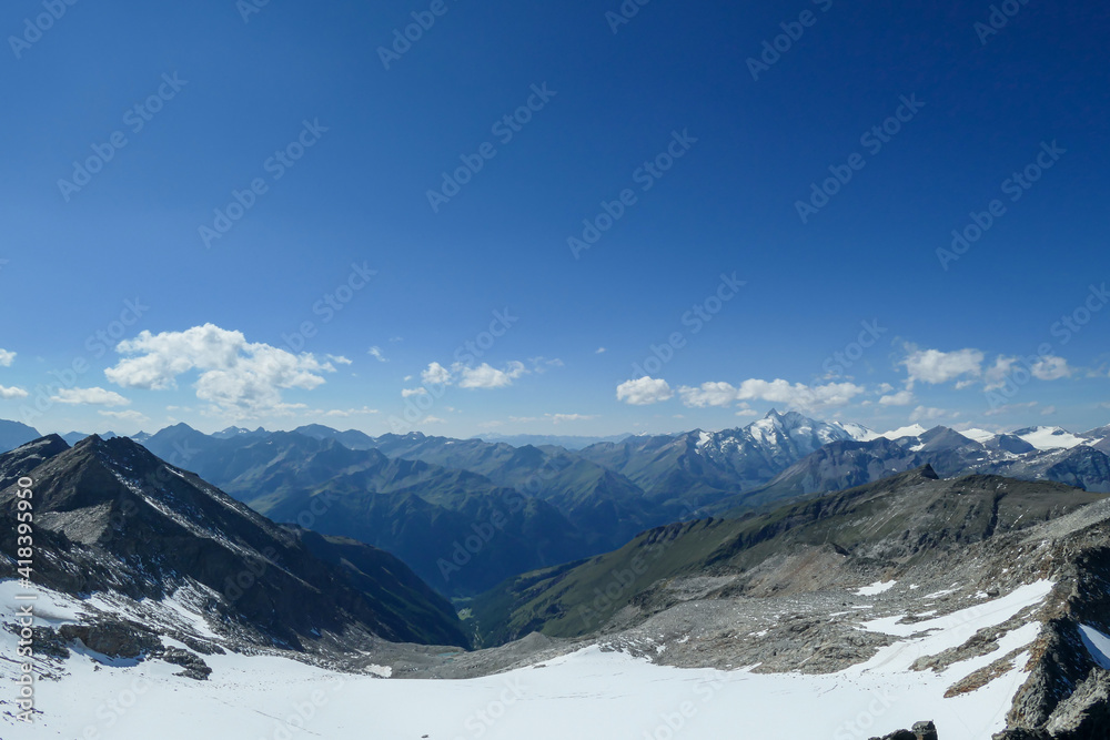 Panoramic view from top of Hohe Sonnblick in Austrian Alps on Grossglockner. The whole area is very steep and dangerous, with many lose stones. Many mountain chains in the back. Sunny day. Expedition