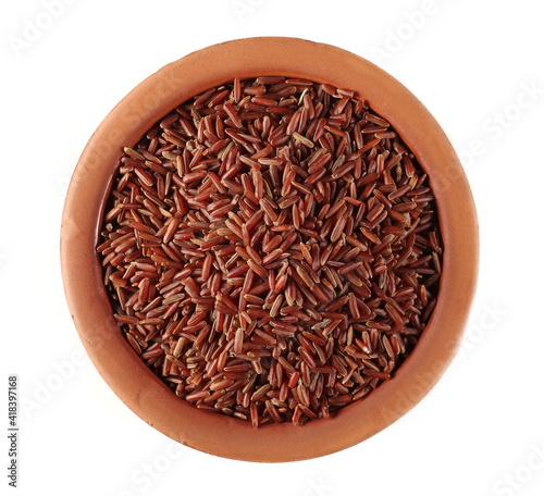 Red wild rice pile in clay pot isolated on white background, top view