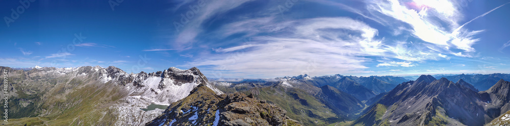 Panoramic view from top of Hohe Sonnblick in Austrian Alps on Grossglockner. The whole area is very steep and dangerous, with many lose stones. Many mountain chains in the back. Sunny day. Expedition