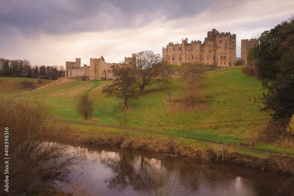 Dramatic and colourful sunset or sunrise clouds above the River Aln and Alnwick Castle, England.