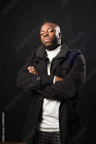 Black man, very serious and with his arms crossed.