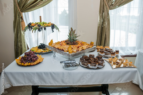 Fruit slicing at a wedding banquet. Watermelon, grapes, strawberry, orange, plum, pear, dinha, peach, kiwi, pineapple, persimmon, apple photo