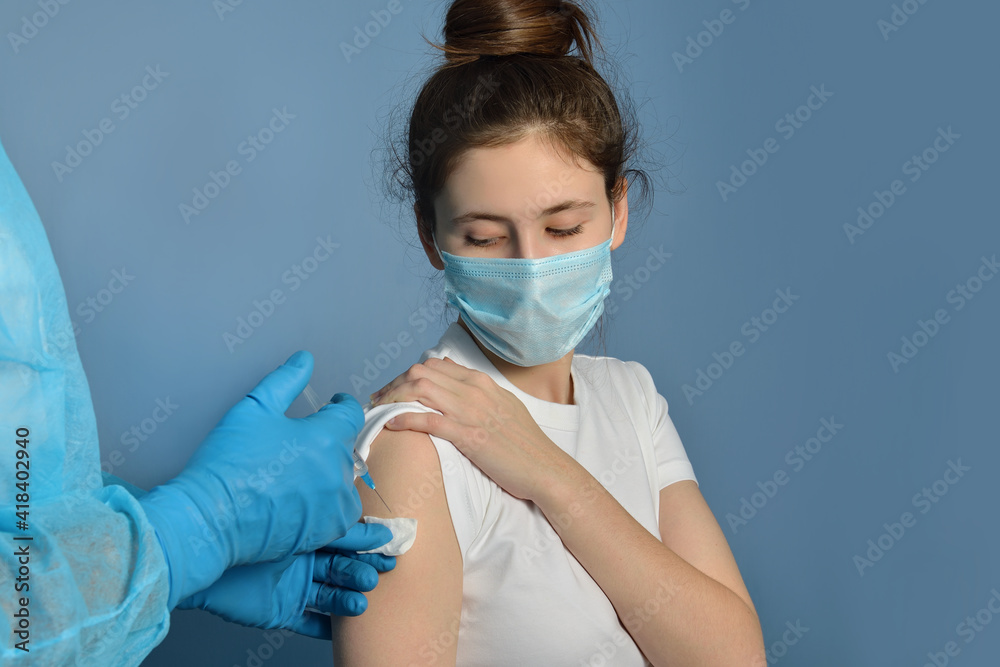 A young girl receiving an immunity shot in the forearm, the concept of vaccination, vaccination, side effects of the vaccine.Closeup of doctor giving Covid-19, AIDS or flu antivirus vaccine to patient