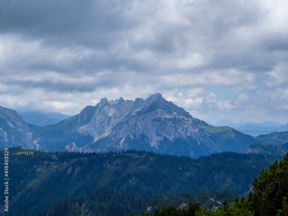 A panoramic view on the mountain chains in Hochschwab region in Austria. The slopes are steep and sharp. Endless chains of the mountains. Overcast and cloudy day. A panoramic view on the mountain chains in Hochschwab region in Austria. The slopes are steep and sharp. Endless chains of the mountains. Overcast and cloudy day.