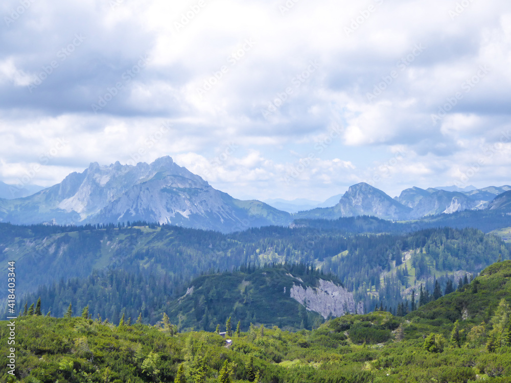 A panoramic view on the mountain chains in Hochschwab region in Austria. The slopes are steep and sharp. Endless chains of the mountains. Overcast and cloudy day.