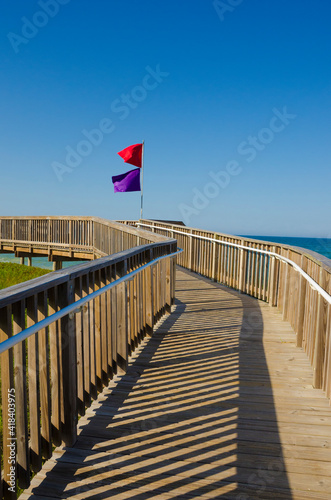 USA, Florida. Boardwalk to beach with flags. © Danita Delimont