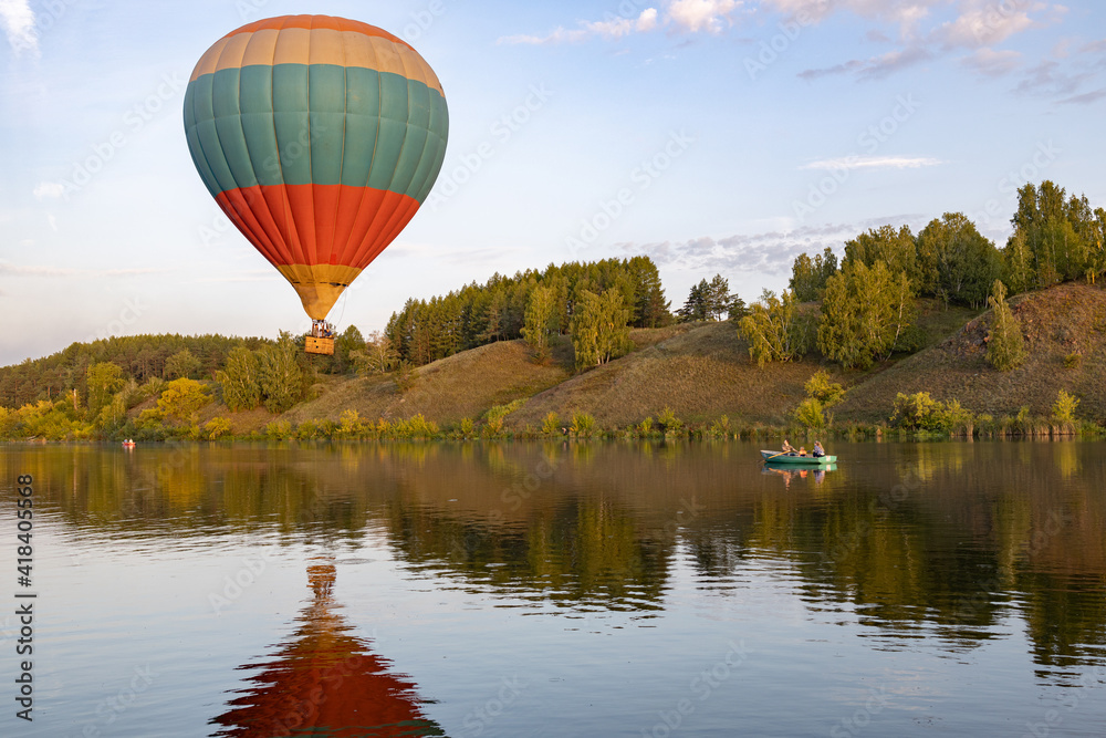 the hot air balloon over the reservoir is very low hovered