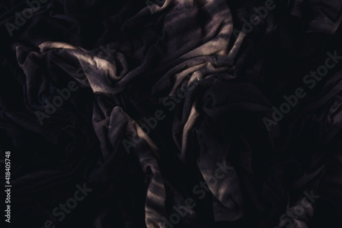 Abstract crumpled darkened black fabric texture background