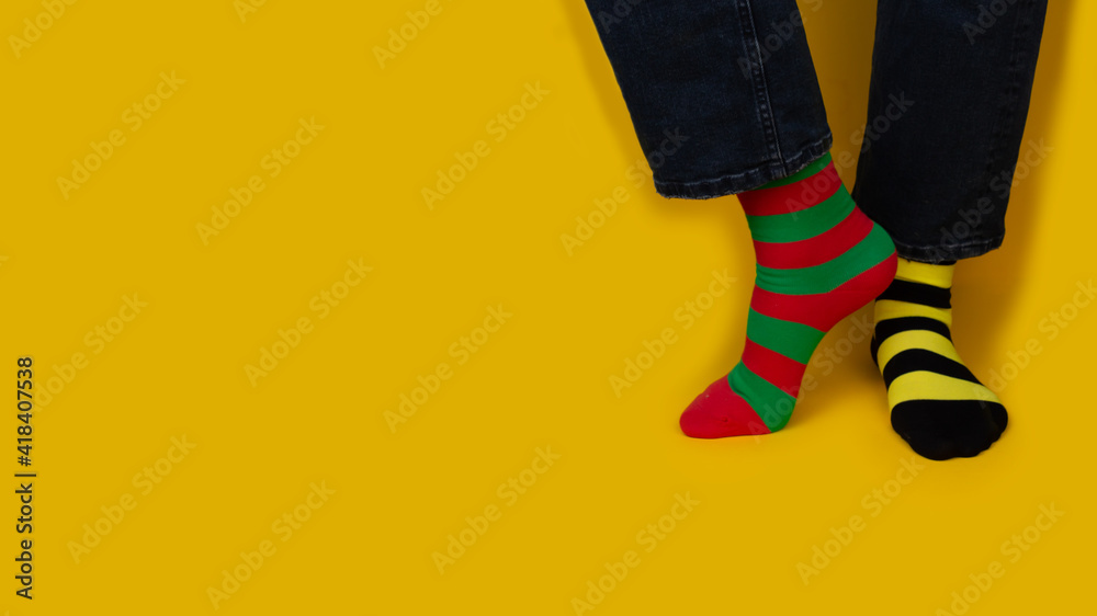 Legs with different stripes socks on background with copy space. World Down syndrome day background. Down syndrome awareness concept. Legs with different stripes socks on background with copy space. World Down syndrome day background. Down syndrome awareness concept.