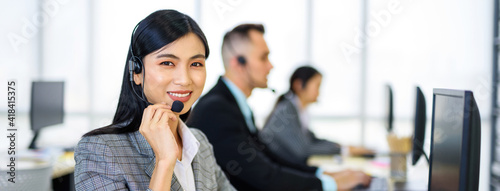 .Asian women public relations or customer service with a hearing aid At her desk looking at the camera And smile.