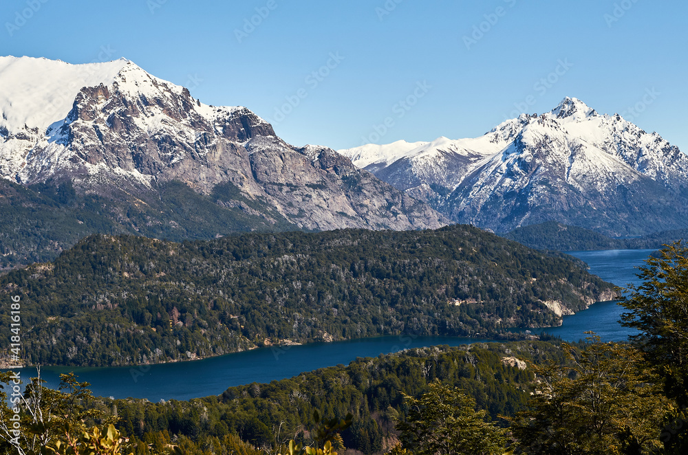 Obraz premium A view of beautiful landscape of snowy mountains and green trees from Cerro Campanario (Campanario Hill) in San Carlos de Bariloche, Rio Negro, Patagonia Argentina.