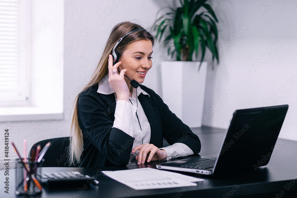 smiling friendly female call-center agent with headset working o smiling friendly female call-center agent with headset working o