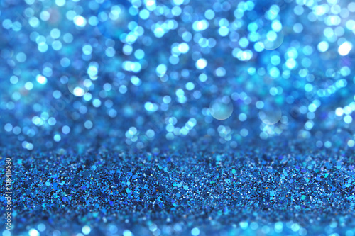 Shiny background. Beautiful glowing bokeh. Bright glowing background. Shiny glowing effect. Blue sequins.
