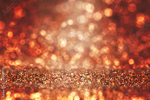Shiny background. Beautiful glowing bokeh. Bright glowing background. Shiny glowing effect. Orange glitter.