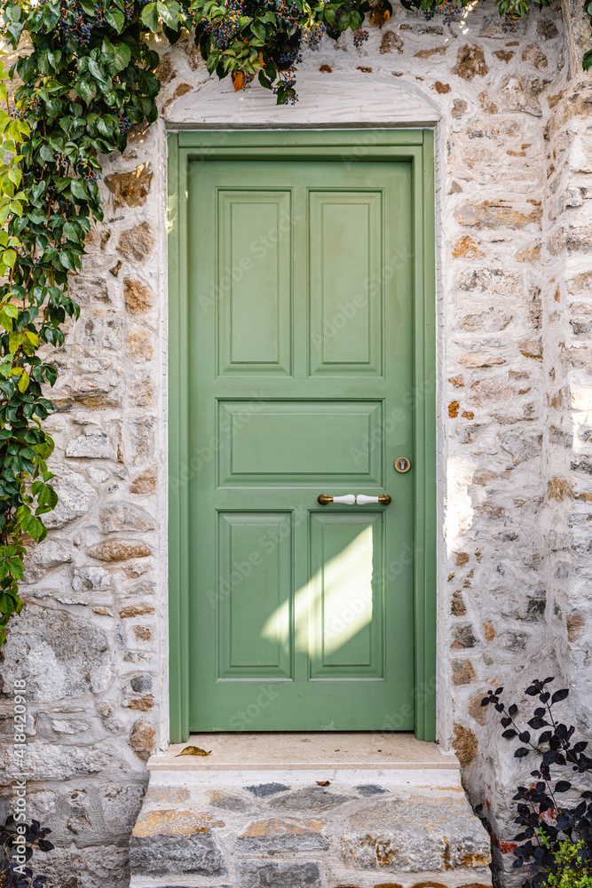 Fototapeta premium Green beautiful door in Marmaris Turkey. External wooden door and ivy on the wall