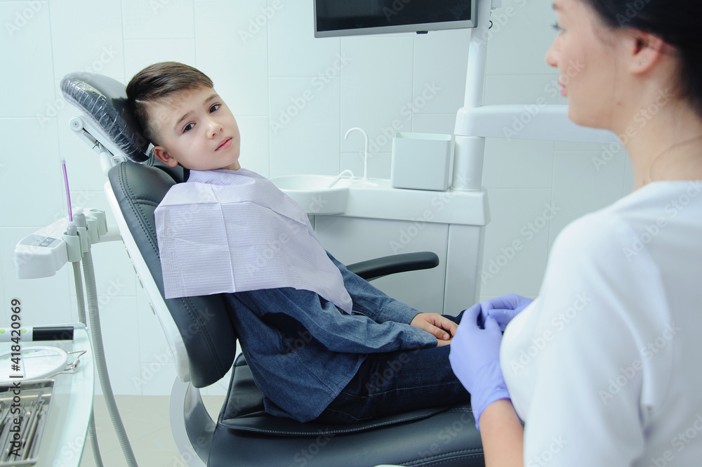 Obraz premium A child boy with a dentist in a dental office
