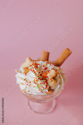 Delicate creamy dessert in a glass on a pink background.