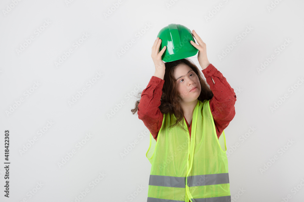 Image of a young cute girl standing in vest and wearing a crash helmet Image of a young cute girl standing in vest and wearing a crash helmet