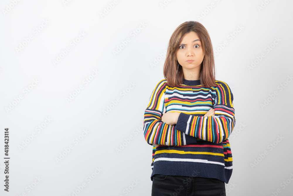 Photo of a cute young woman model standing and posing with crossed arms Photo of a cute young woman model standing and posing with crossed arms