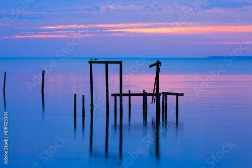 USA, Florida. Apalachicola, Remains of an old dock at sunrise. photo