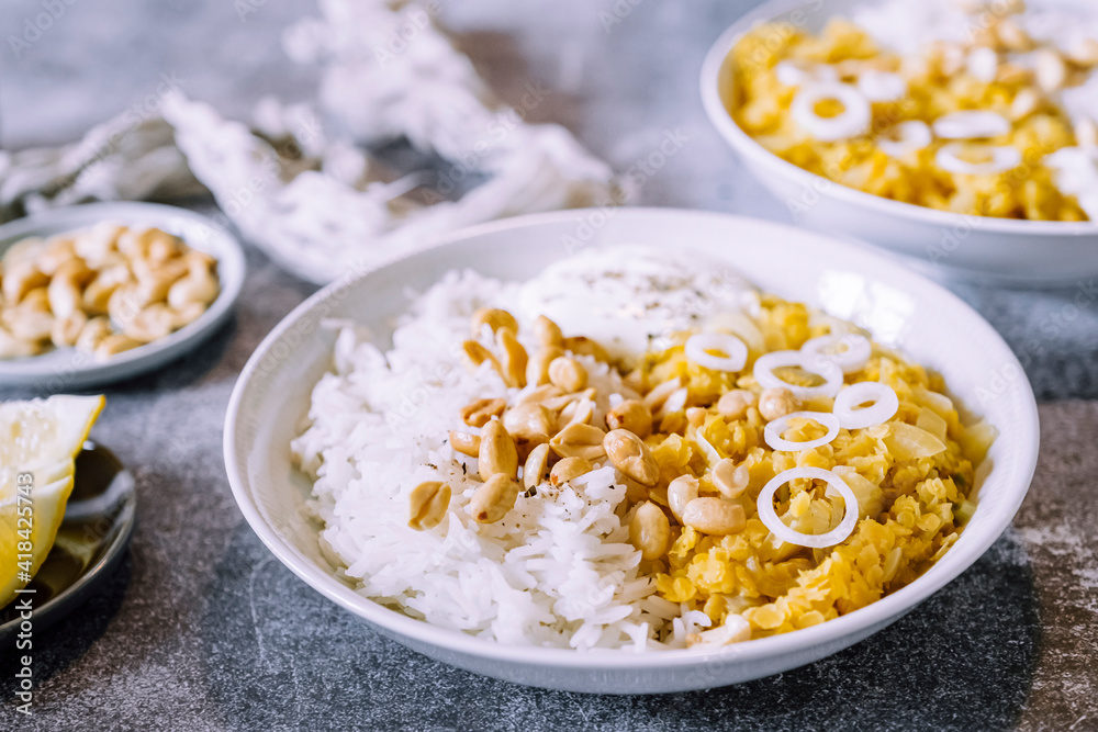 Plat de dahl de lentilles corail aux cacahuètes et oignons frais accompagné de riz Plat de dahl de lentilles corail aux cacahuètes et oignons frais accompagné de riz