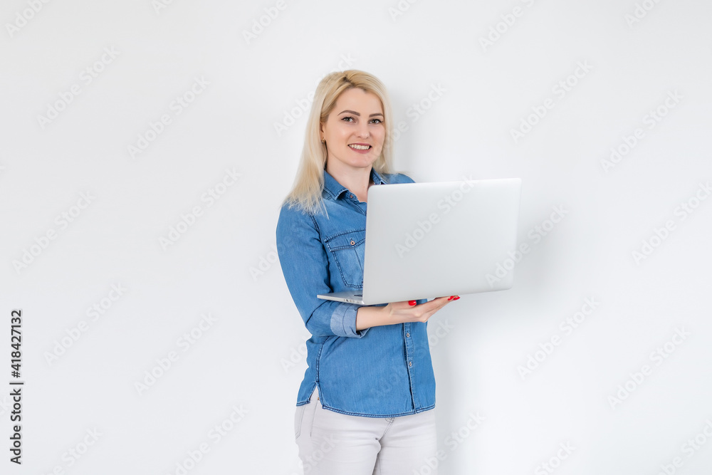 Concentrated at work. Confident young woman in smart casual wear working on laptop while sitting near window in creative office or cafe Concentrated at work. Confident young woman in smart casual wear working on laptop while sitting near window in creative office or cafe