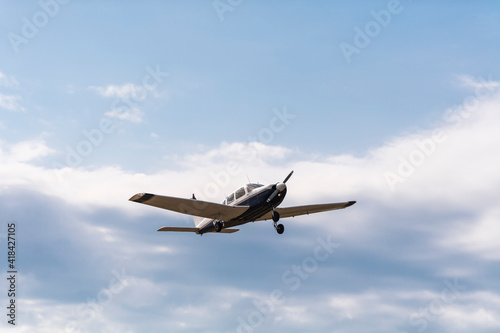 A light aircraft taking off into the cloudy blue sky