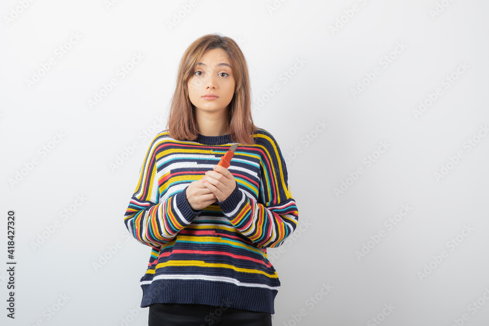 Portrait photo of a young pretty woman model standing and holding box cutter Portrait photo of a young pretty woman model standing and holding box cutter