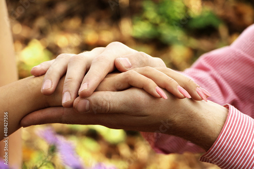 A man holding a girl's hands