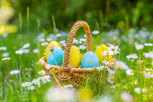 viele bunte Ostereier in einem Korb auf der Wiese	
