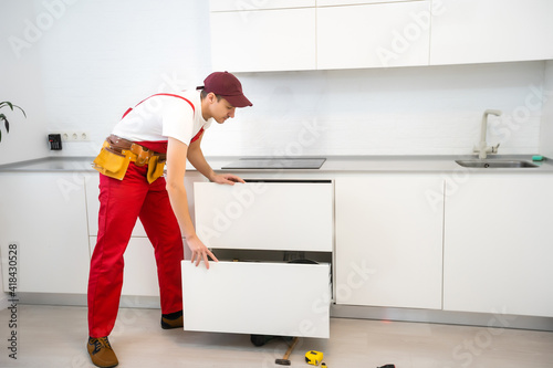 Fotografie Young man assembling kitchen furniture.