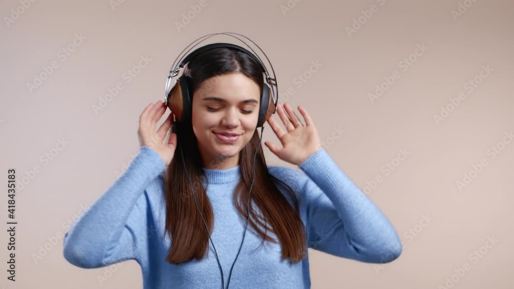 Charming woman dancing with headphones on studio background. Cute girl portrait. Music, radio, happiness, freedom, youth concept. Charming woman dancing with headphones on studio background. Cute girl portrait. Music, radio, happiness, freedom, youth concept.