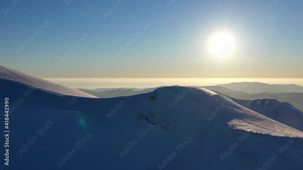 snow-covered mountain peaks above the clouds, against the backdrop of a clear blue sky snow-covered mountain peaks above the clouds, against the backdrop of a clear blue sky