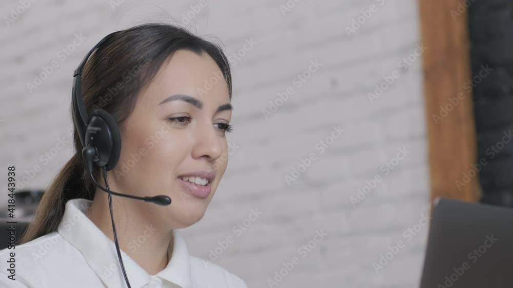 Smiling woman call centre operator, customer support agent wears headset consults client online typing on laptop, talk in internet computer chat, helpline operator secretary make conference video call Smiling woman call centre operator, customer support agent wears headset consults client online typing on laptop, talk in internet computer chat, helpline operator secretary make conference video call