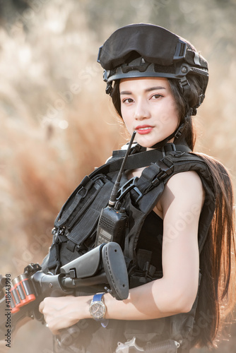 Portrait of beautiful sexy woman with shotgun and Pistol in a shooting computer game ESports SWAT fighter, police tactical concept..