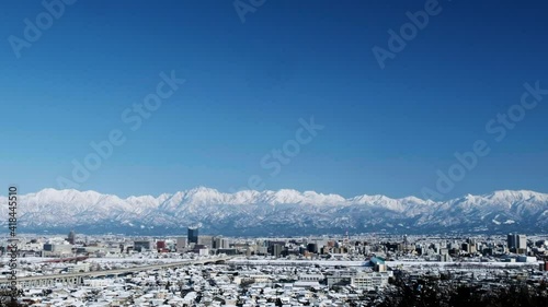 呉羽山展望台からの広い青空と北アルプスパノラマ剱岳立山連峰と雪に覆われた富山市街地2021.2.19
